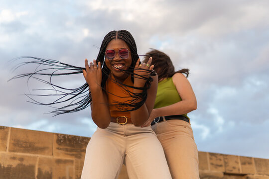 Young woman smiling with braids flying in wind