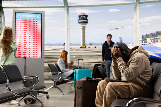 Digital nomad professional waiting for delayed flight in airport lounge, receiving bad news about plane departure, Traveler conveys flexible job, online productivity during nomadic lifestyle.