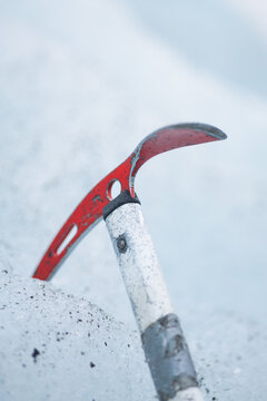View of a red ice axe embedded in the frozen surface of a glacier in Iceland.