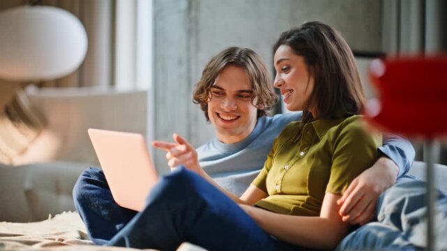 Cheerful pair looking computer modern bedroom closeup. Young man cuddling woman