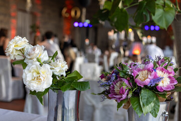 Obraz premium Celebration setting with flower arrangements on tables and guests enjoying their time together at a venue during evening hours