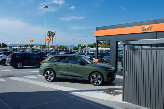 Green suv driving past car rental office at airport