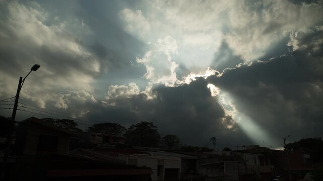 Dramatic timelapse fast moving clouds crepuscular rays over San Jose Costa Rica rooftops