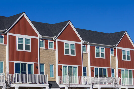 Modern townhouses with red siding and balconies