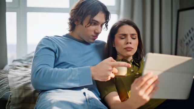 Pair discussing tab news sitting comfortable apartment floor closeup. Two lovers