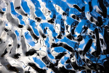 Fototapeta premium Silver and blue light spots on a black water surface