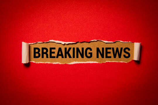 Breaking News Text Revealed Through Torn Red Paper Background.
