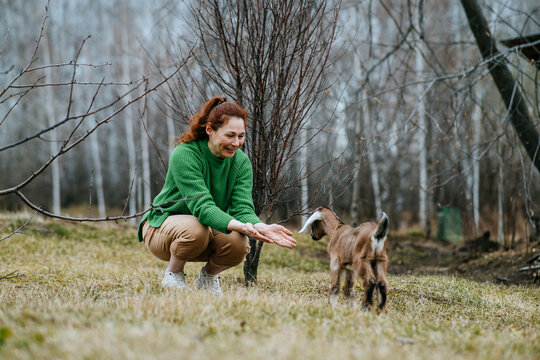 Woman Nurturing Goat on Rural Homestead