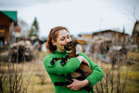 Woman with Nubian Goat in Rustic Homestead Setting