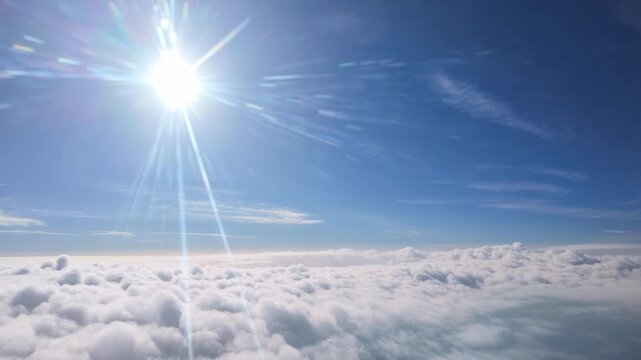 Spain Europe. 28.05. 2026. Video.  View from an airplane window with the early morning sun shining brightly through scattered clouds and a clear blue sky above