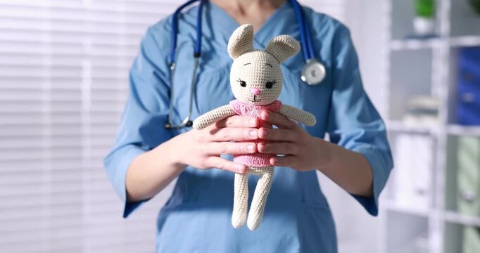 Pediatrician with toy bunny in hospital, closeup