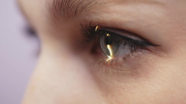 Close-up view of a woman's eye examined with a slit lamp, highlighting the iris and pupil details, showcasing the examination process in a clinical setting