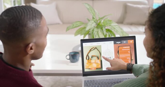 Diverse couple after man's gesture, pointing at laptop at home and reviewing Black Friday deals