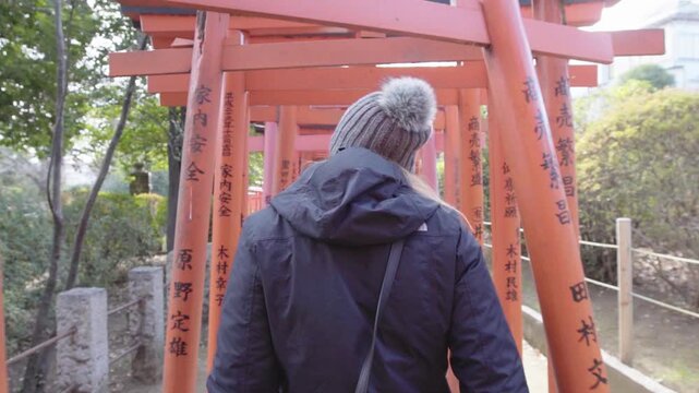 Slow motion woman red torii gates winter Japan