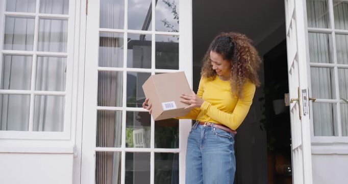 Woman in yellow top spotting package stepping out to retrieve parcel, checking barcode closing door