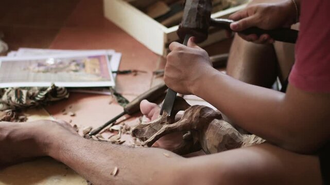 Skilled artisan carving intricate wooden horse sculpture using chisel and mallet.