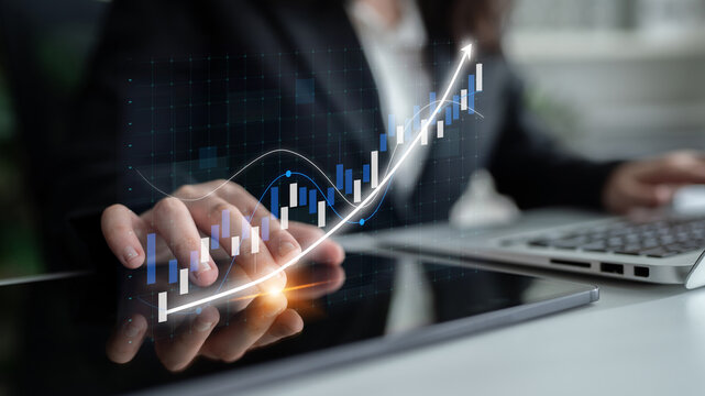A business professional analyzes financial growth data displayed on a tablet, showcasing graphs and charts that signify success and market trends in modern business. Impute