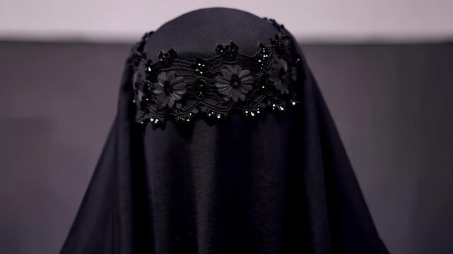 AI generated 4k video of black beaded niqab standing under moody studio lighting.