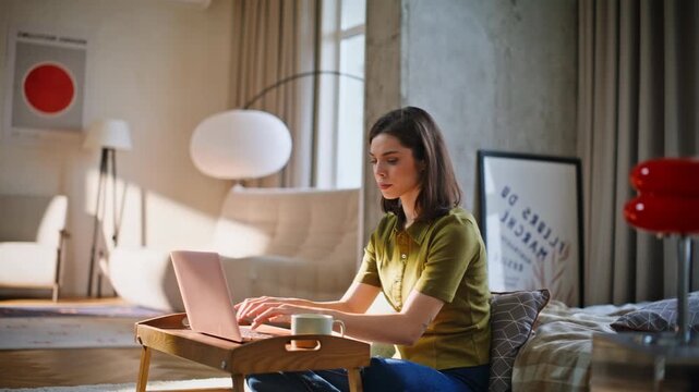 Lady freelancer entering laptop data making coffee sip in sunny cozy apartment