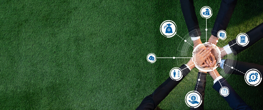 This image depicts a diverse group of business professionals collaborating for sustainable development, highlighting teamwork and innovative solutions represented by icons on grass. Amity