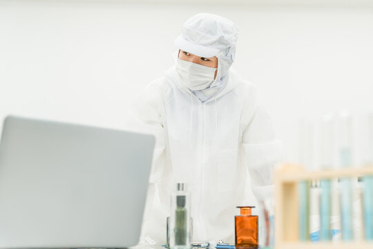 薬品工場,製薬会社で薬品開発をするクリーンスーツを着たスタッフ