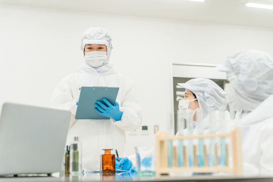 薬品工場,製薬会社で薬品開発をするクリーンスーツを着たスタッフ