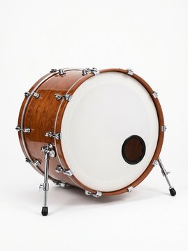 A beautiful wooden bass drum with a white head and a port hole rests on a white background with its legs extended