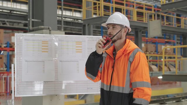 Worker reviews an Electric Train blueprint within sprawling industrial factory setting, wearing safety vest and hard hat for critical engineering supervision during operations.
