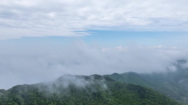 Aerial hyperlapse of thick fog and mist moving over Seongjusan Mountain in Boryeong, South Korea