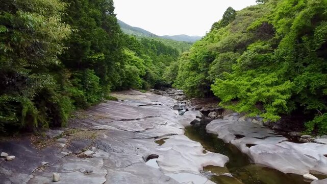The suspension bridge and unique granite riverbed with potholes at Ayumodoshi Natural Park on Tsushima Island, Nagasaki Prefecture, Japan.