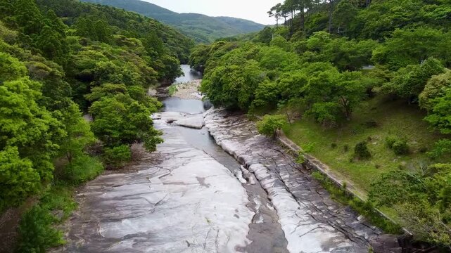 The suspension bridge and unique granite riverbed with potholes at Ayumodoshi Natural Park on Tsushima Island, Nagasaki Prefecture, Japan.