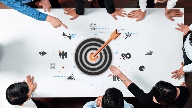 A dynamic team of professionals focuses on a central target during a strategic meeting in a modern office, emphasizing collaboration and goal achievement. Raster