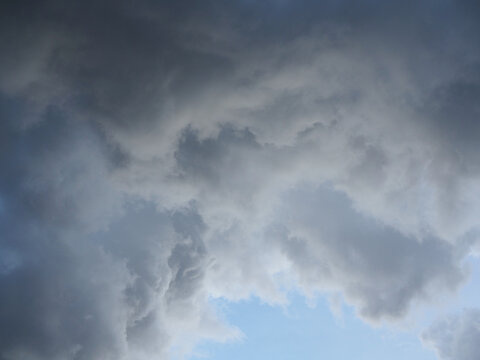 A large, gray cloud loomed in the sky; a rainstorm was imminent. The weather looked dark and gloomy.