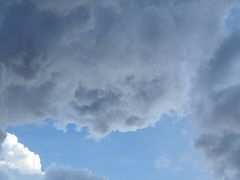 A large, gray cloud loomed in the sky; a rainstorm was imminent. The weather looked dark and gloomy.