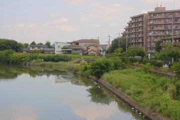 Fototapeta premium Scenery of Calm Ayase River and Townscape Viewed from Gamo-Ohashi Bridge