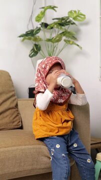 Asian Little girl child drinking milk. healthy eating a child eating breakfast kid dream concept. daughter girl in kitchen drinks yogurt milk. 
