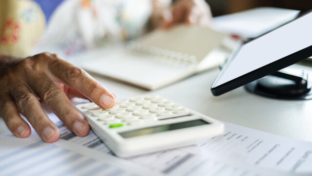 close-up shot, casual man working at home using wireless technology to start new business online, E-commerce via digital tablet, calculate business cost