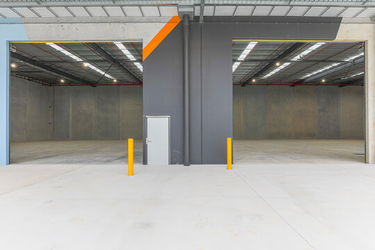 Modern industrial warehouse with open loading bays, concrete hardstand and high clearance interiors. Commercial logistics facility designed for freight, storage and distribution.