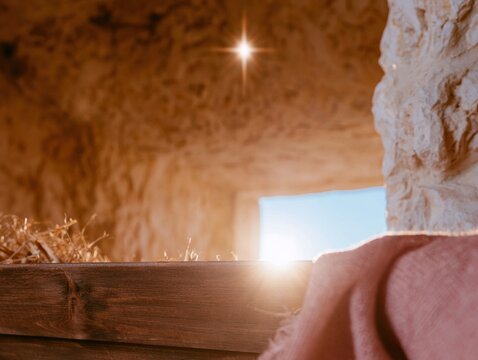Empty wooden manger inside a glowing stone cave under a radiant star for Christmas nativity and religious holiday storytelling