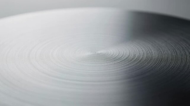 Close up of circular metal texture with concentric patterns and smooth gradient lighting