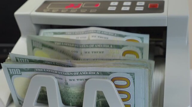 Electronic Money Counting Machine with Red Digital Display Processing a Stack of US 100 Dollar Bills