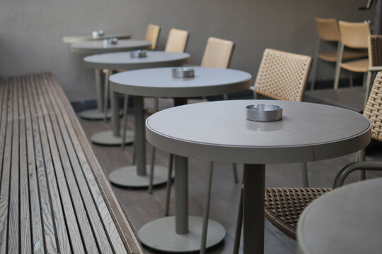 Outdoor cafe seating with empty tables and chairs