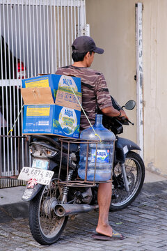 Man riding old motorbike to deliver mineral water from grocery shop in Yogyakarta, June 19, 2026