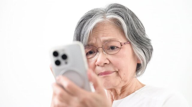 老眼鏡でスマホを見るグレイヘアのシニア女性　文字が見えにくい動画