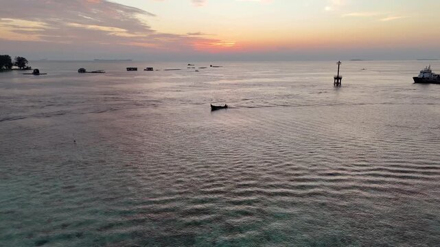 Stunning drone shot of Karimun Jawa coastline during a vibrant golden hour sunset.
