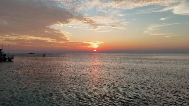 Stunning drone shot of Karimun Jawa coastline during a vibrant golden hour sunset.