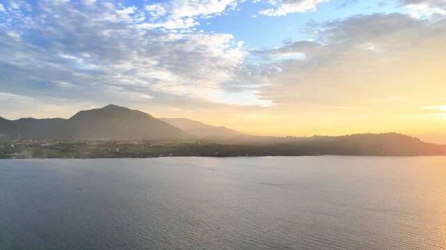 Toba, Indonesia - May 29, 2025: Cinematic aerial view of sunset at Pasir Putih Beach, Balige