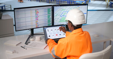Woman Using Laptop In Busy Warehouse Managing Inventory © Andrey Popov