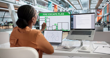 Young Woman Fire Safety Officer Plans Emergency Evacuation Routes © Andrey Popov