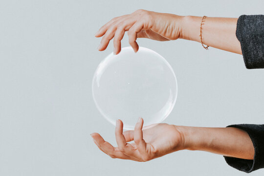 Hands holding clear sphere gracefully